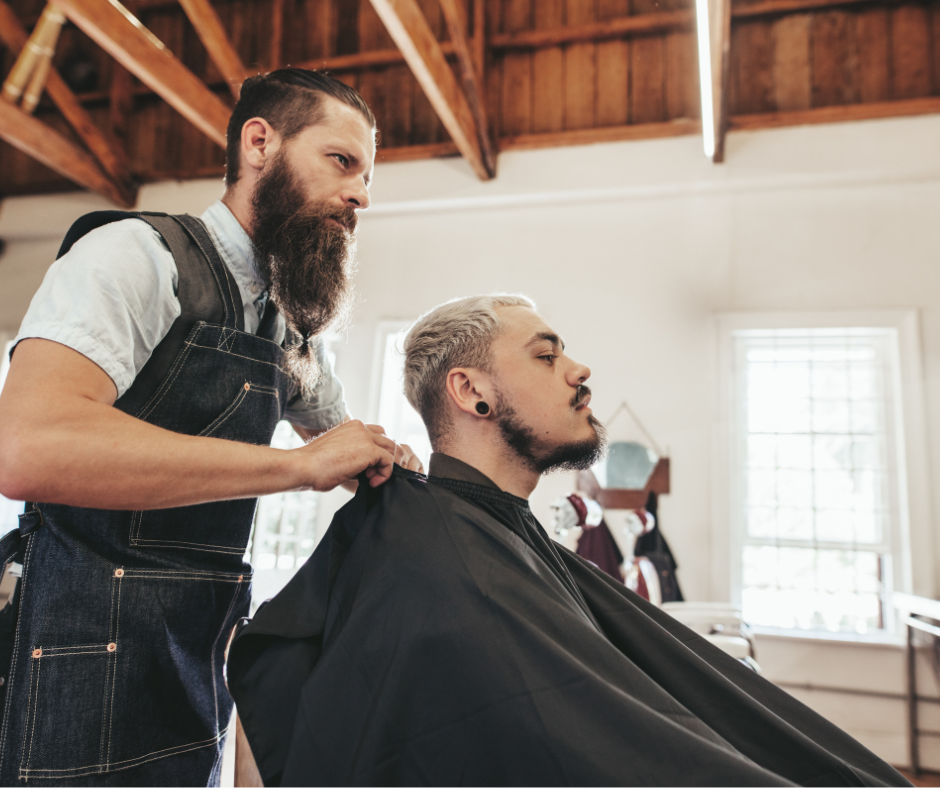 Man sitting in salon chair with hairstylist behind him